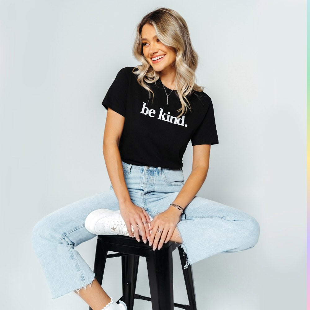 A woman wearing the black be kind tee.